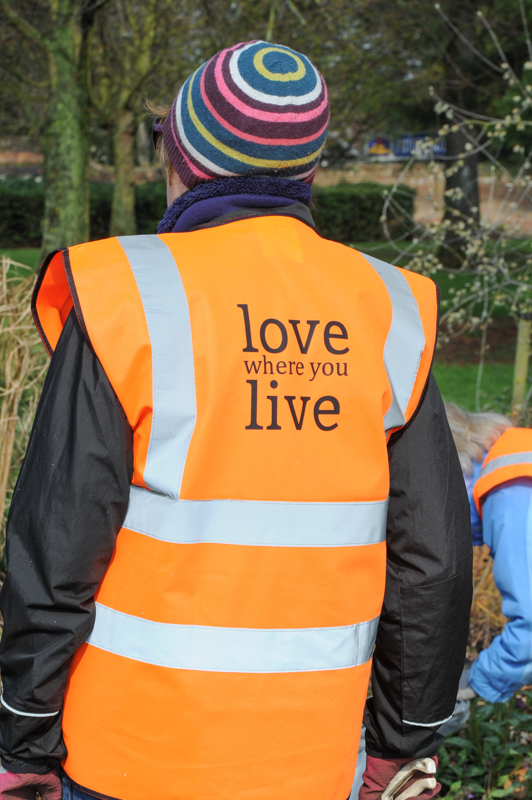 Love where you live slogan on a hi-vis jacket worn by one of the volunteers at the Tollgate Triangle tidy-up
